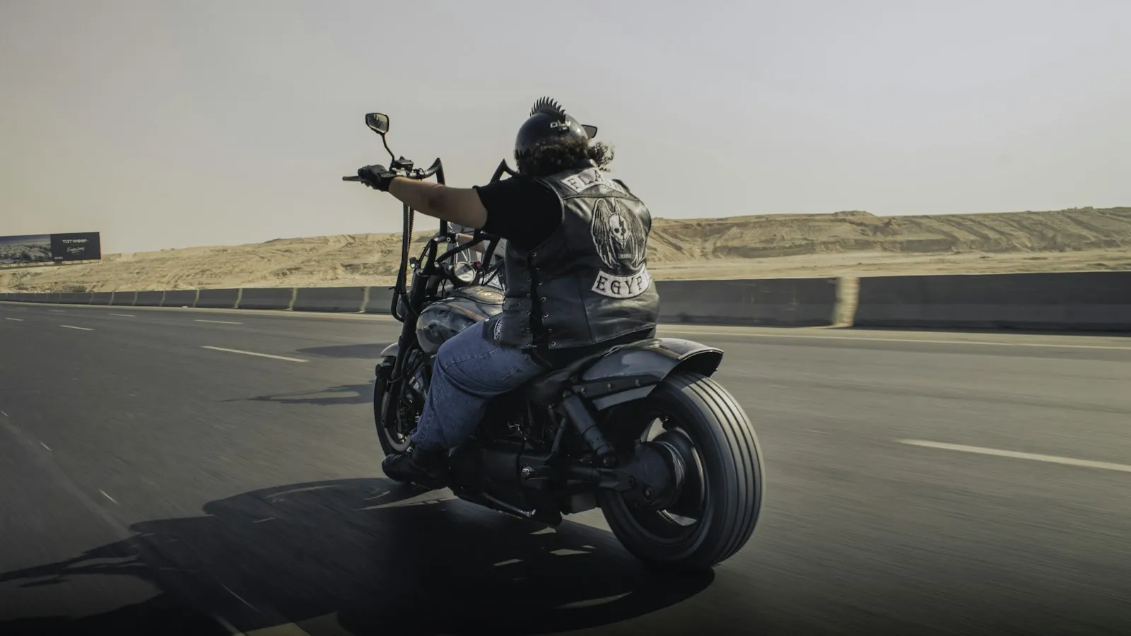 biker adjusting motorcycle windscreen on highway